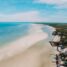 Große Sandbank vor der Insel Holbox direkt vor dem von Palmen gesäumten Strand m Norden bei blauem Himmel