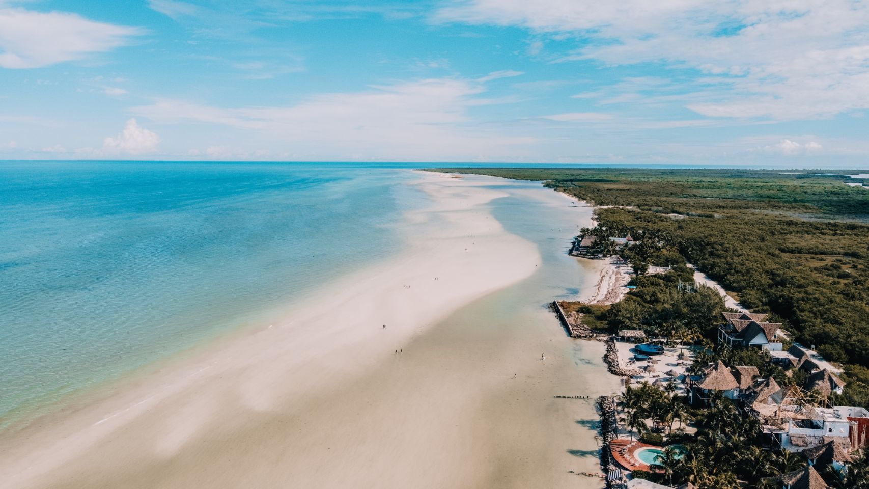 Große Sandbank vor der Insel Holbox direkt vor dem von Palmen gesäumten Strand m Norden bei blauem Himmel